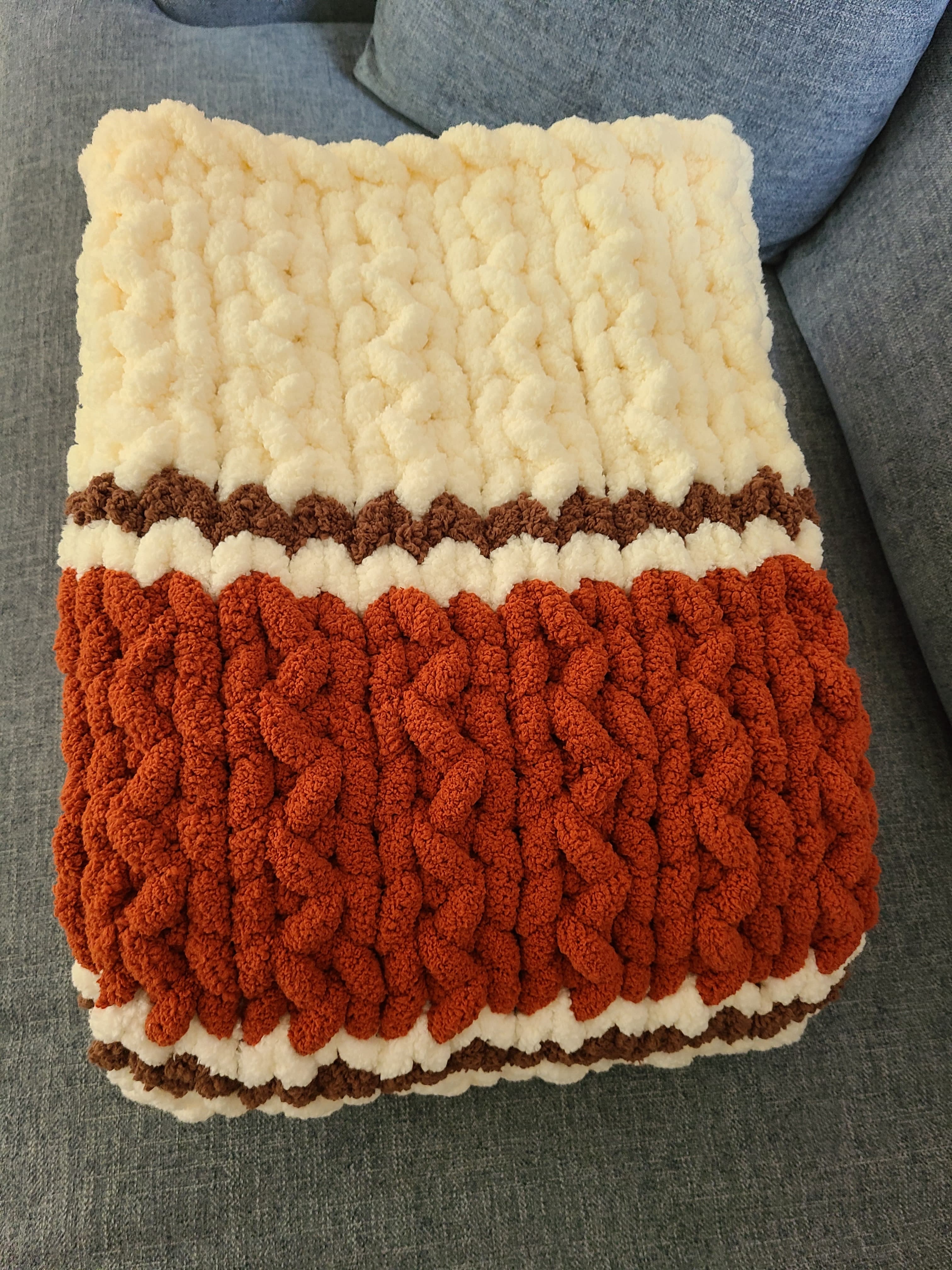 Autumn Ember — copper, coffee brown, and vintage white — folded on a sofa showing the wide copper band