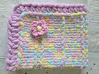 Lullaby Blossom baby blanket — pastel plaid with a lilac border — laid flat showing the full pattern