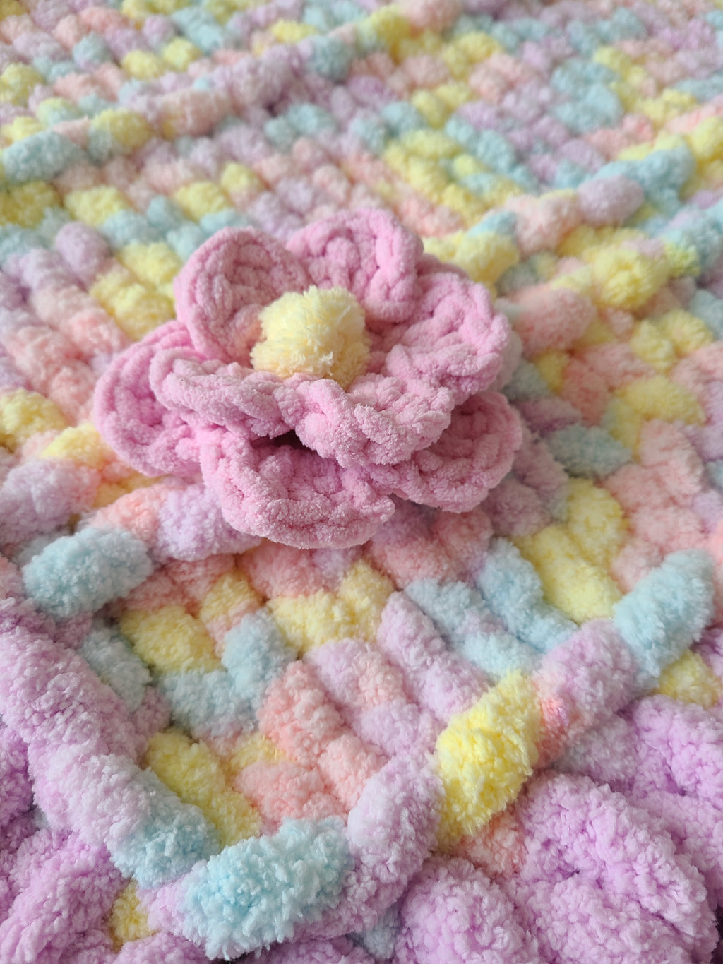 Lullaby Blossom baby blanket — pastel plaid with a lilac border — macro of the multi-petal crochet flower