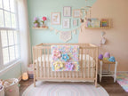 Wildflower Whisper baby blanket — pastel macaron tones — shown over a wooden crib in a mint and blush nursery
