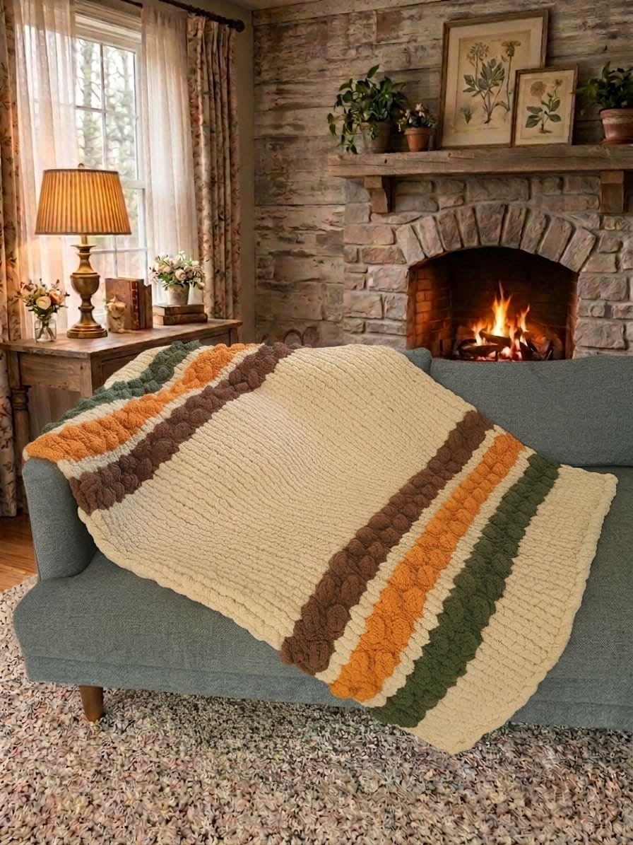 Woodland Ridge — olive, butterscotch, and taupe on oatmeal — draped over a sofa beside a lit stone fireplace