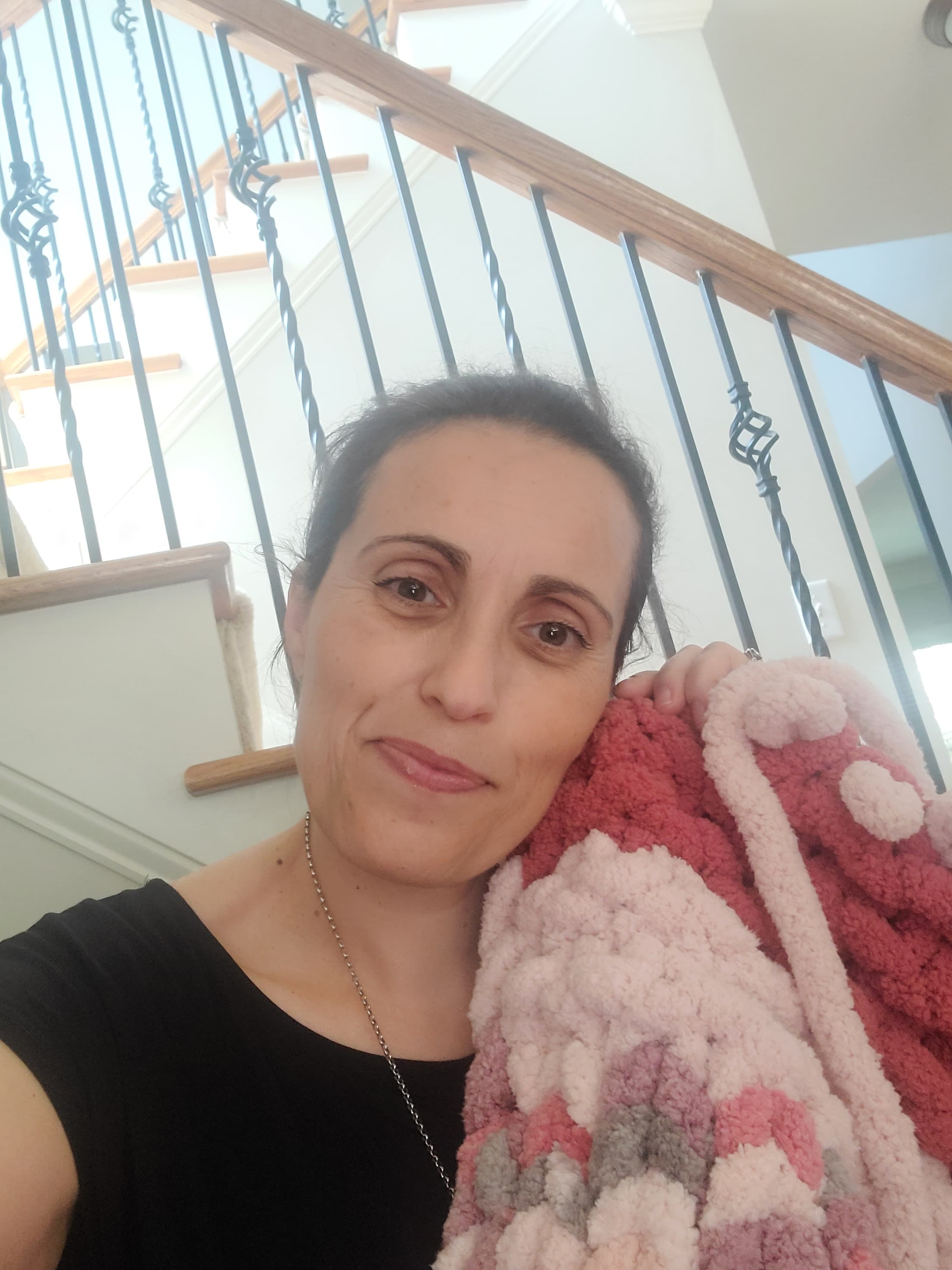 Sonia, founder of Hearth & Haven, holding one of her hand-knit chenille blankets